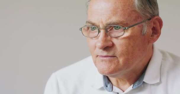 Detailní portrét seriózního šedovlasého staršího muže v brýlích — Stock video