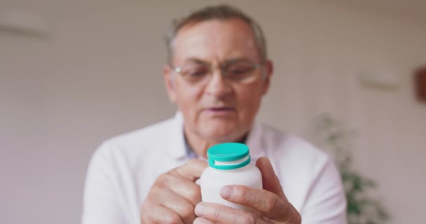 Un aîné lit une étiquette sur une bouteille de médicament — Video