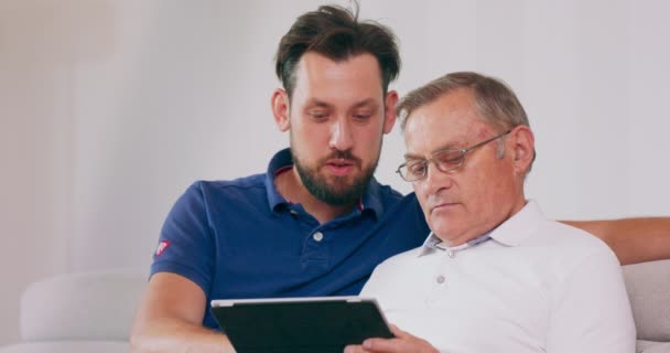 Mężczyzna uczy ojca, jak robić zakupy online. — Wideo stockowe
