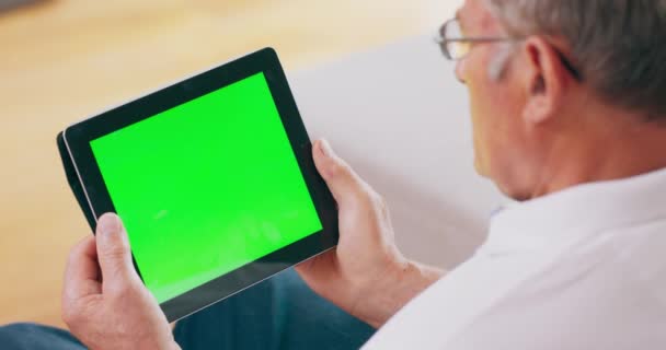 Un adulto mayor toma una videollamada en una tableta, que cuenta con una pantalla verde — Vídeos de Stock