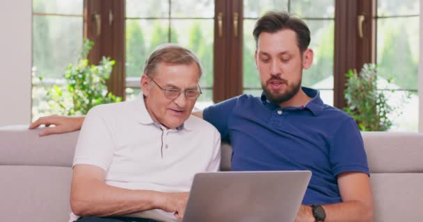 Ein Mann bringt seinem Vater bei, wie man online einkauft — Stockvideo