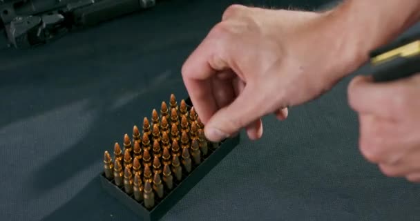 Zbliżenie męskich rąk ładujących kule do magazynka z bronią na strzelnicy — Wideo stockowe