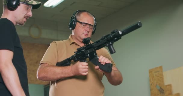 Estudante estressado se prepara para o primeiro tiro do rifle na faixa de tiro — Vídeo de Stock