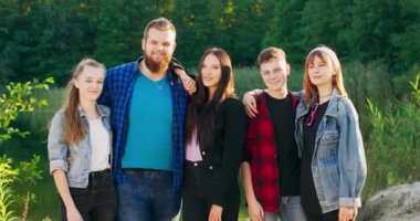 Bir grup neşeli Kafkas genci dışarıda dikiliyor.