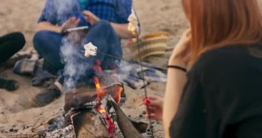 Şenlik ateşinin yanında oturan bir grup arkadaş.