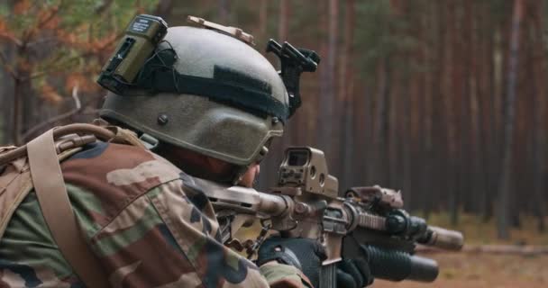 Kafasında miğfer, ormanda dürbünlü tüfekle özel askeri üniformalı bir asker. — Stok video