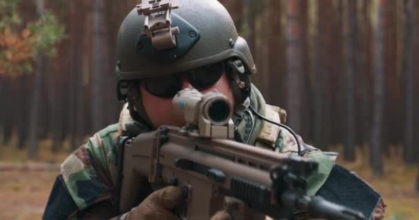 頭にヘルメットを被った特殊部隊の兵士とスコープを狙って森の狙撃銃 — ストック動画