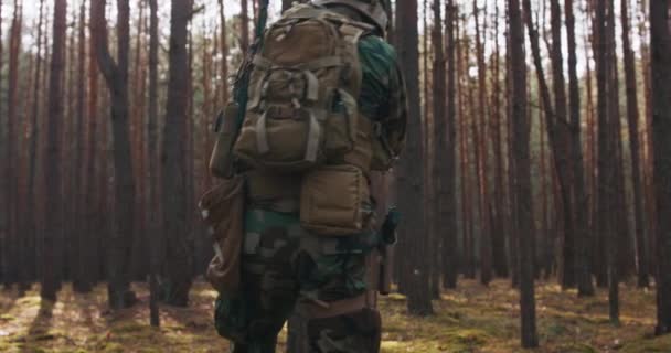 Fuldt udstyrede soldater iført camouflage ensartet angreb fjendtlige rifler i fyring holdning militære operation i aktion trup opholder sig i dannelse gennem tæt skov ved middagstid – Stock-video