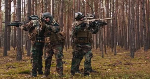 네 명의 온전 한 장비를 갖춘 중년층 군인들 이 위장을 하고 적군을 공격하는 장면 준비 태세를 갖춘 소총을 쏘면서 Dense 숲에 서 있는 행동 부대에서 작전을 수행하는 장면 — 비디오