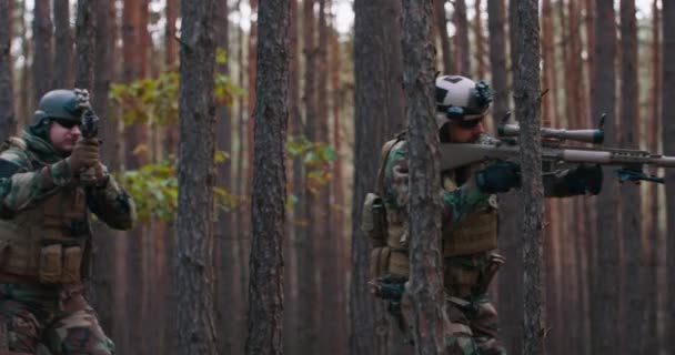 Escuadrón de soldados durante la operación militar camuflaje totalmente equipado en una misión militar de reconocimiento rifles en posición de disparo Vuelven a correr en formación a través del denso bosque — Vídeos de Stock