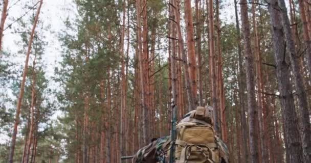 Befälhavaren på fullt utrustade soldater i kamouflage uniformer beordrar bildandet att vara redo att avfyra Soldater sikta sina gevär En militär operation i aktion en enhet som står i en tjock tallskog — Stockvideo