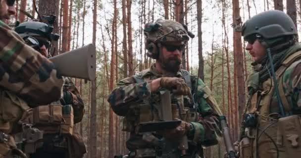 Staffelleiter bespricht militärische Einsatzdetails mit Soldaten Kommandant erteilt Befehle Voll ausgerüstete und bewaffnete Soldaten bereit für den Einsatz in einem dichten Wald — Stockvideo