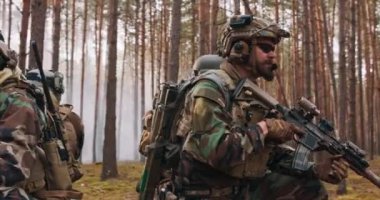 Dört tam teçhizatlı orta yaşlı asker kamuflaj üniforması giyiyorlar. Atışa hazırlar. Harekat Tüfeği Harekât Tüfeği yoğun ormanda çömeldi.