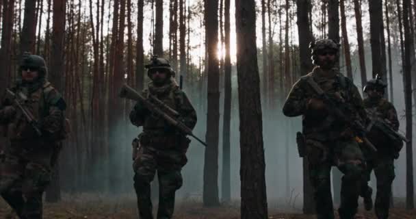 身着迷彩服、装备齐全的士兵从战场返回军事行动部队在浓烟密布的森林中排成队形行进 — 图库视频影像