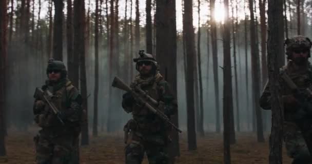 Volledig uitgeruste soldaten dragen camouflage Uniform Aanvallende Vijandelijke Geweren Klaar om te schieten Militaire Operatie in Actie Squad wandelen in formatie door donkere dichte Smokey Forest — Stockvideo