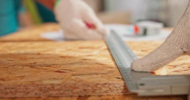 Bir marangoz atölyesindeki tahtayı ölçerken elinde açısal bir cetvel ve kalem tutan çalışkan bir marangozun yakın çekiminde sakallı bir DIY meraklısı tahtayı ölçer.
