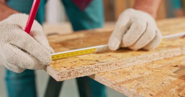 Close-up of a hardworking professional carpenter holding a ruler and pencil while measuring a board in a carpentry workshop. A bearded DIY enthusiast measures wood. There are a locksmith table and — Stock Video