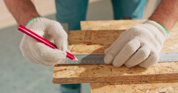 Großaufnahme eines fleißigen professionellen Tischlers, der Lineal und Bleistift in der Hand hält, während er in einer Tischlerei ein Brett misst. Ein bärtiger Heimwerker misst Holz. Es gibt einen Schlossertisch und — Stockvideo