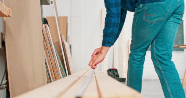 Εργατικός επαγγελματίας ξυλουργός κρατώντας ένα χάρακα και μολύβι, ενώ η μέτρηση μιας δέσμης σε ένα εργαστήριο ξυλουργικής Ένας γενειοφόρος DIY ενθουσιώδης μέτρα ξύλο — Αρχείο Βίντεο