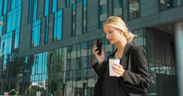 Avvocato - giovane avvocato donna caucasica guardando smartphone mobile e bere caffè da usa e getta — Video Stock