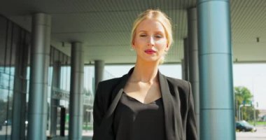 İş kadını, profesyonel ya da benzer bir şekilde dışarıda yürüyen çok ırklı beyaz iş kadını kameraya bakıyor.