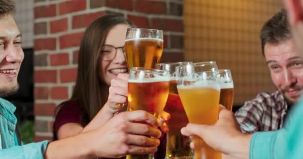 Grupo de amigos disfrutando de una cerveza en un pub de Polonia, brindis y risas - Multiracial — Vídeo de stock