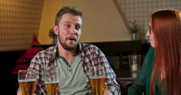 Freunde lachen, trinken Bier und Cocktails und amüsieren sich gemeinsam an einer Bar — Stockvideo