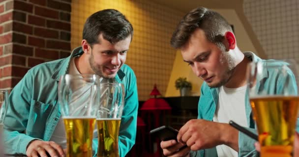 Retrato de dois de feliz hipster estudantes assistindo vídeo, foto no telefone inteligente — Vídeo de Stock