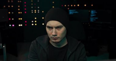 Gözlerinin altında siyah halkalar olan genç, yorgun bir hacker şirketin verilerine giriyor.