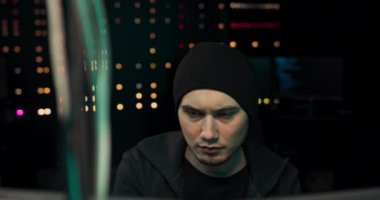 Kulaklık ve gözlüklü hackerın klavye hackleme bilgisayar sistemi veya programlama sığınağı var