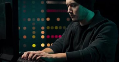 Eşofman üstü ve kapak giyen konsantre ve endişeli Hacker 'dan Şirket Veri Sunucularına sızıyor