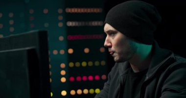 Sweatshirt 'lü ve şapkalı bilgisayar korsanı yeraltı sığınağından şirket sunucularına giriyor.