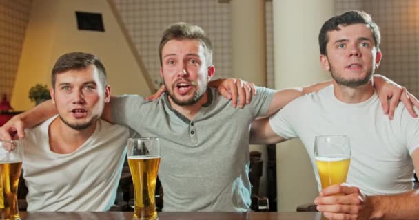 Fröhliche alte Freunde, die Spaß daran haben, sich ein Fußballspiel im Fernsehen anzusehen und Bier vom Fass zu trinken — Stockvideo