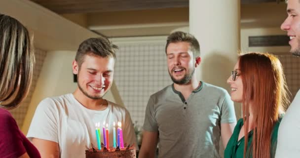 Happy friends celebrate their boyfriends birthday The birthday boy sfoukne svíčky — Stock video
