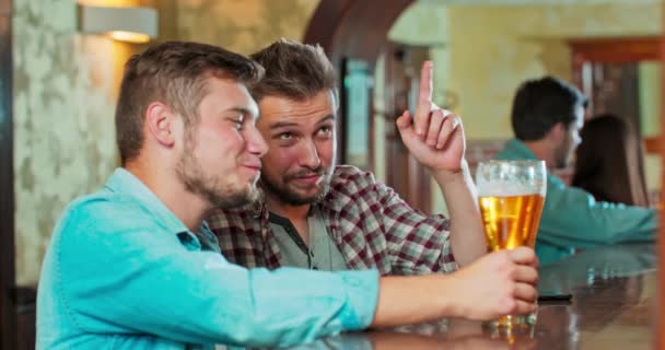 Uśmiechnięci beztroscy przyjaciele pijący razem w barze Grupa szczęśliwych młodych mężczyzn pijących zimno — Wideo stockowe