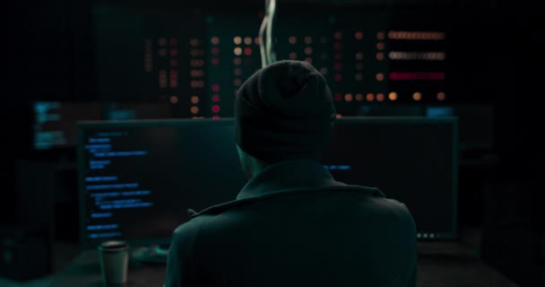 带有键盘黑客攻击计算机系统或编程Hideout Place的耳机中的黑客具有黑暗的氛围 — 图库视频影像