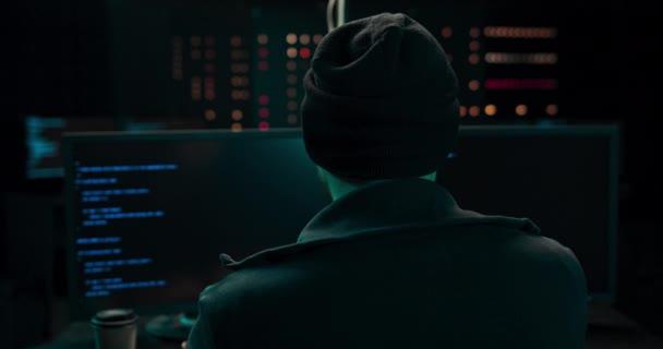 Shot from the Back to Hooded Hacker Breaking into Corporate Data Servers from His Underground — Vídeo de Stock