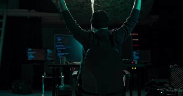 Hacker con capucha usando su computadora con diferente información para irrumpir en servidores de datos corporativos y — Vídeo de stock