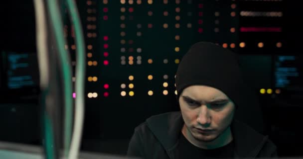 Um jovem hacker cansado com círculos escuros sob seus olhos está usando o computador para organizar — Vídeo de Stock