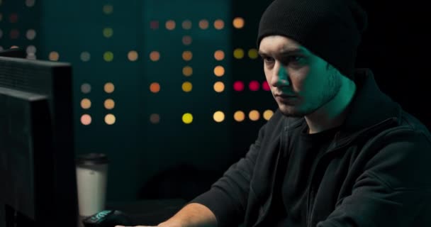 Porträt eines Hackers mit Sweatshirt und Mütze versucht, ein Sicherheitssystem zu hacken, um — Stockvideo