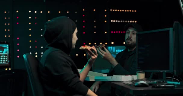 Os hackers comem pizza e conversam em um esconderijo secreto enquanto escrevem malware — Vídeo de Stock