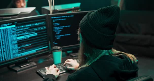 Від спини до з капюшоном жінка хакер розбивається на корпоративні сервери даних від його — стокове відео