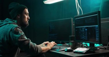 Erkek hacker tehlikeli bir kötü amaçlı yazılımı klavye kullanarak banka sistemine sızıyor.
