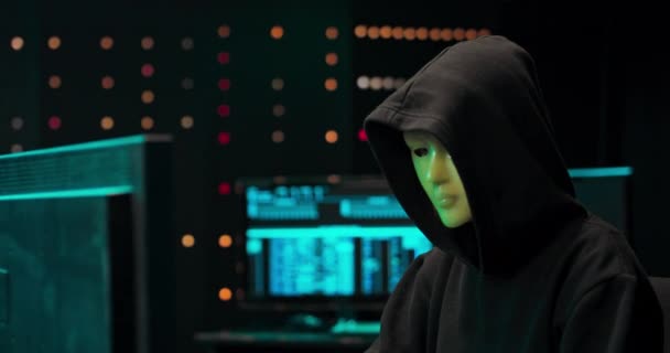 Pirata informático anónimo en máscara y sudadera con capucha Oscuro cara oscura utilizando la computadora para el ataque cibernético — Vídeo de stock