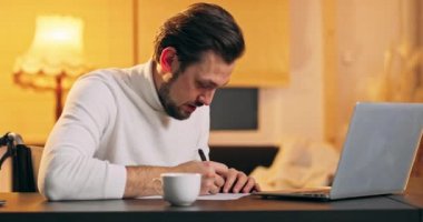 Tekerlekli sandalyedeki adam Not yaz ve dizüstü bilgisayardaki engelli genç adama bak