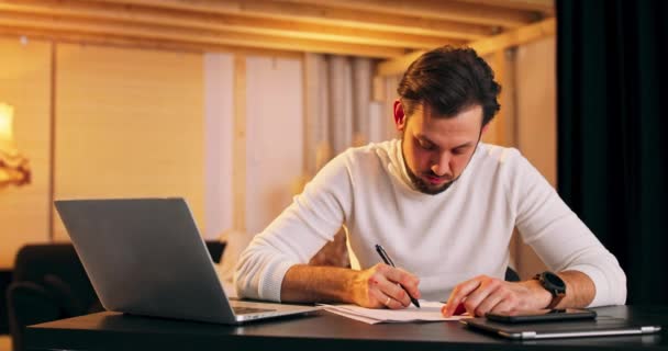Muž píše s perem v zápisníku, že pracuje v podkroví. — Stock video