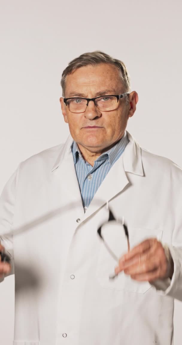 Een ervaren arts, een professional, een chirurg, trots op zijn werk, gekleed in een wit — Stockvideo