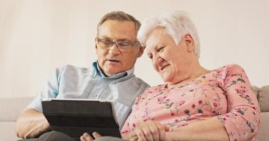 Büyükannem ve büyükbabam sıcak oturma odalarında kanepede oturuyorlar. İkisi de.