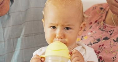 Güzel, tatlı, sarı saçlı, kahverengi gözlü, kameraya bakan, kusursuz bir cildi olan bir bebek.,