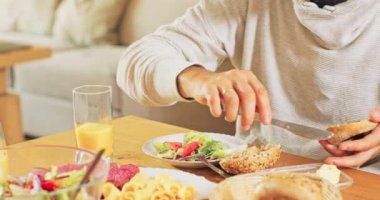 Kahvaltı için zengince hazırlanmış bir masa et ve peynir tabağı, salata ve ekmek.